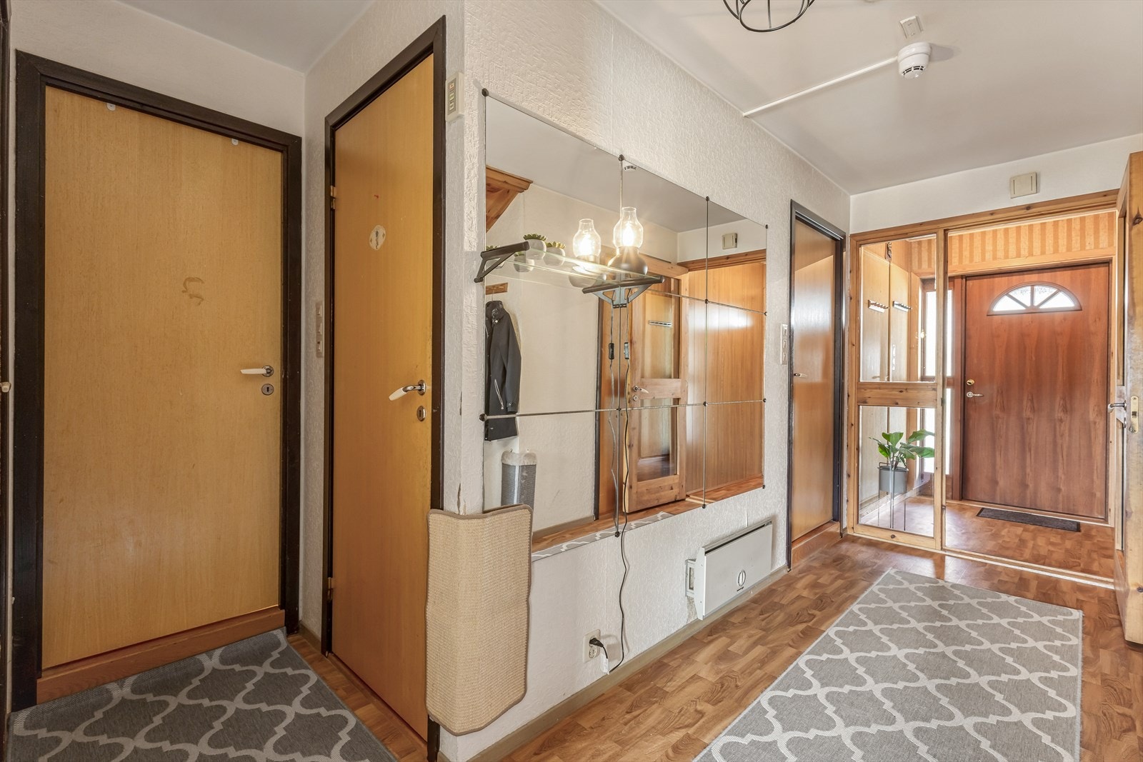 Innenfor døren ligger en romslig entré med en praktisk bod til høyre. Videre forgrener gangen seg til de andre rommene i etasjen. Galleribilde