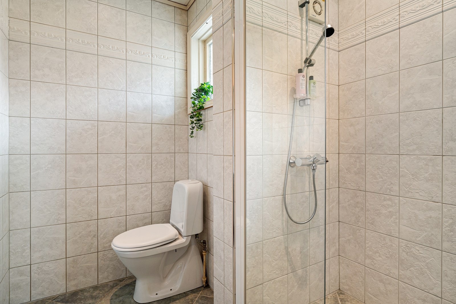 Hovedbadet i første etasje er romslig og funksjonelt, med fliser på både gulv og vegger. Galleribilde