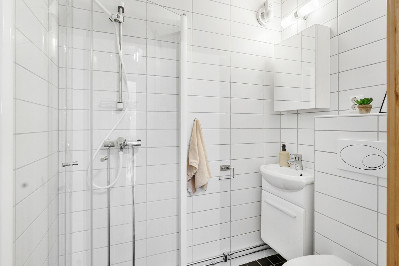 Lyst og pent bad med adkomst fra entré - Hovedbadet er i underetasjen, sammen med soverommene Galleribilde