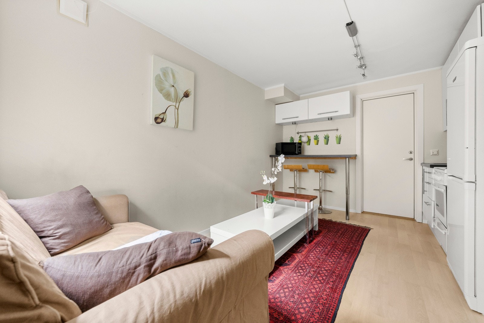 Stuen i hybeldelen har en åpen løsning mot kjøkkenet og byr på en hyggelig atmosfære med plass til både en sofagruppe og en mindre spisestuedel. Galleribilde