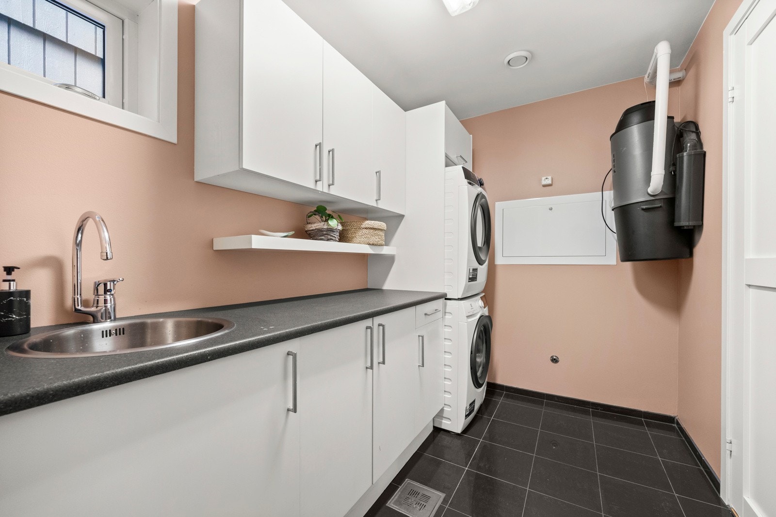 Vaskerommet, som er plassert i boligens 1. etasje, har flislagt gulv med varmekabler og malte vegger. Galleribilde