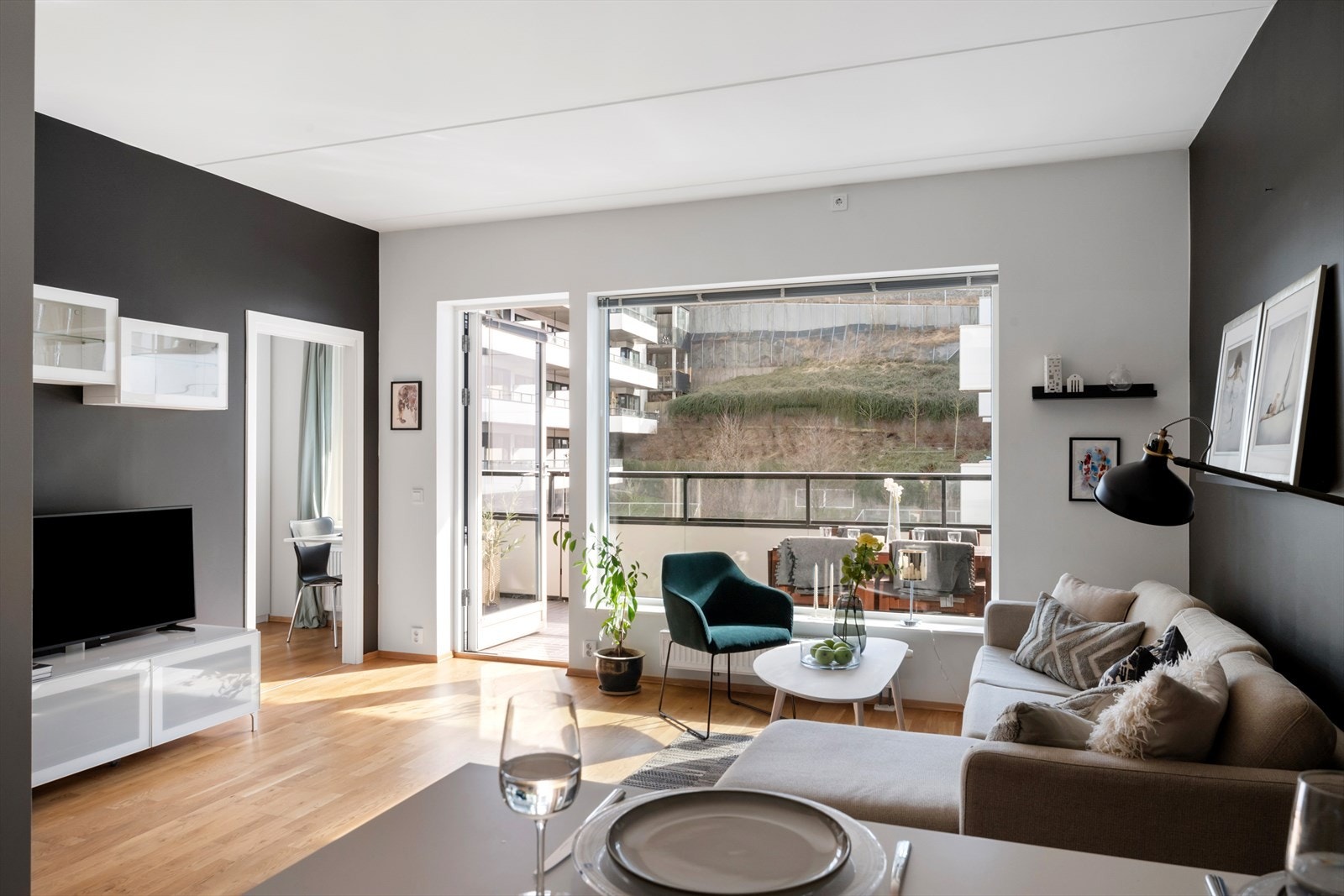 Åpen kjøkkenløsning mot stue, samtidig tilbaketrukket fra sofagruppe Galleribilde