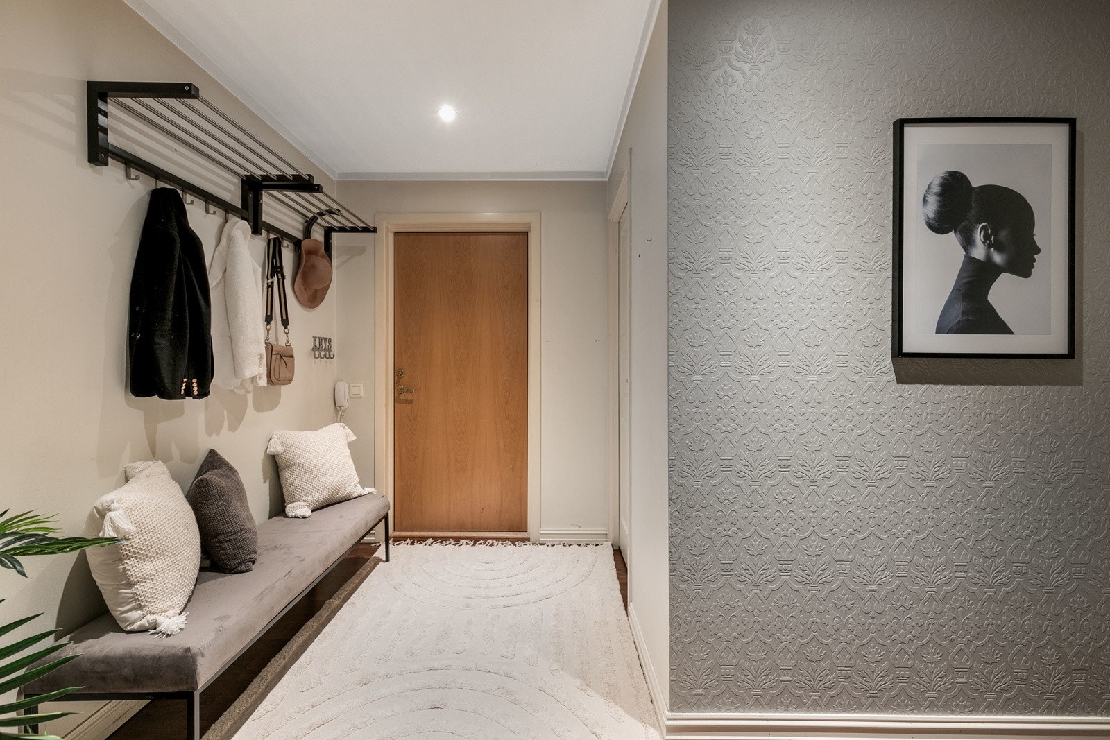 Lys entre med eikeparkett på gulv og lysmalte overflater på vegger. Galleribilde