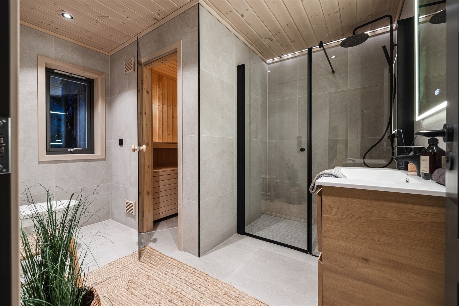 Lekkert filslagt bad med sorte detaljer og badstu Galleribilde