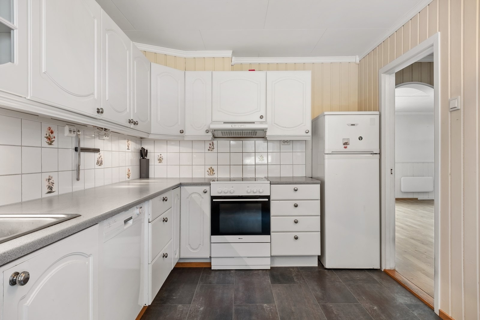 Lyst og nøytralt kjøkken med rikeleg med skap og benkplass. Galleribilde