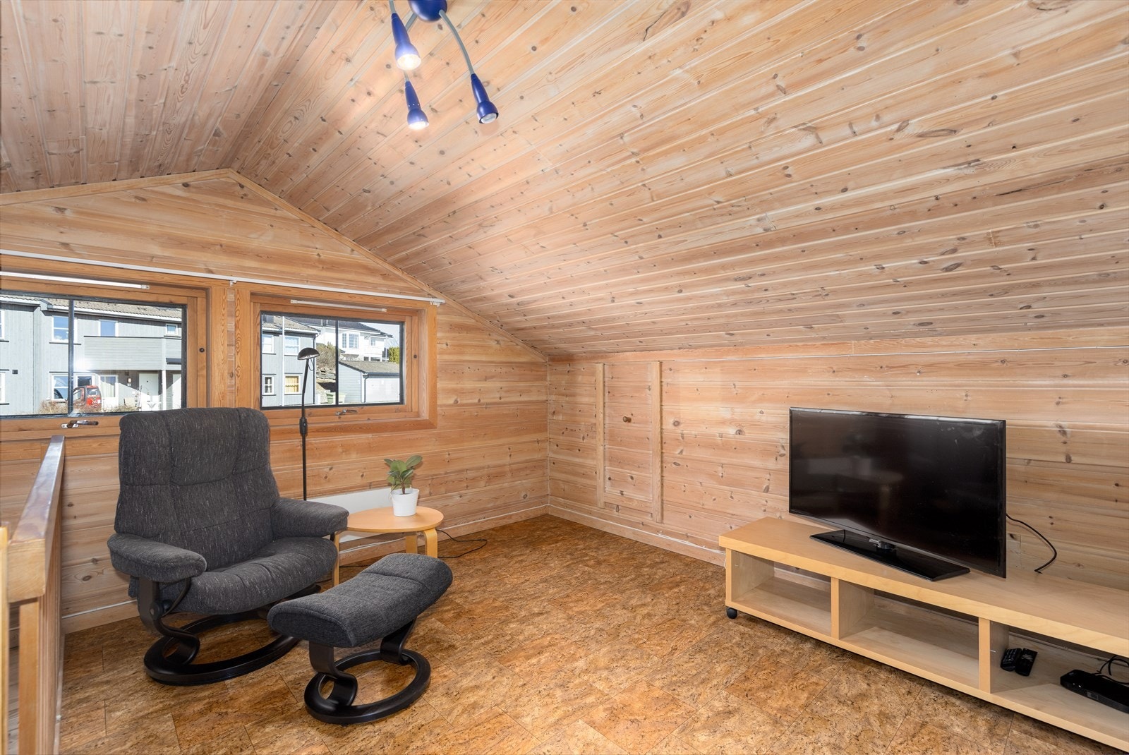 Lys og trivelig loftstue med vinylbelegg på gulv, panel på vegger og i tak. Galleribilde