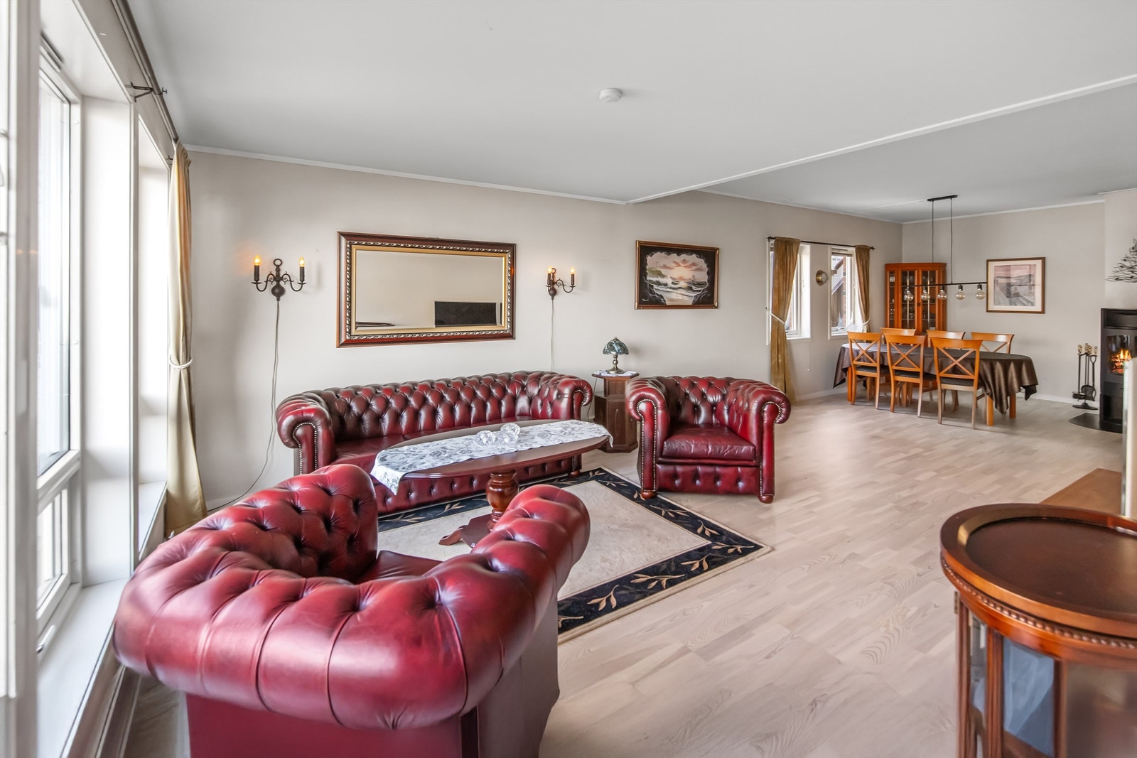 Romslig stue med plass til flere sittegrupper Galleribilde