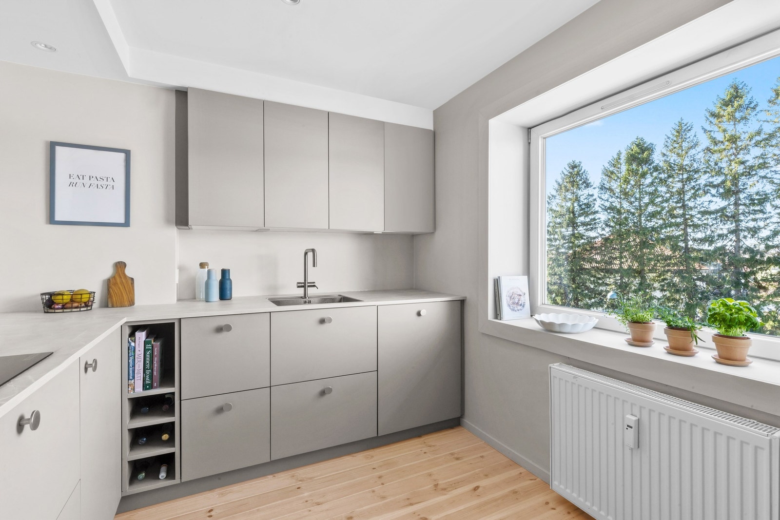 Lyst og innbydende kjøkken med stort vindu som slipper inn rikelig med naturlig lys. Galleribilde
