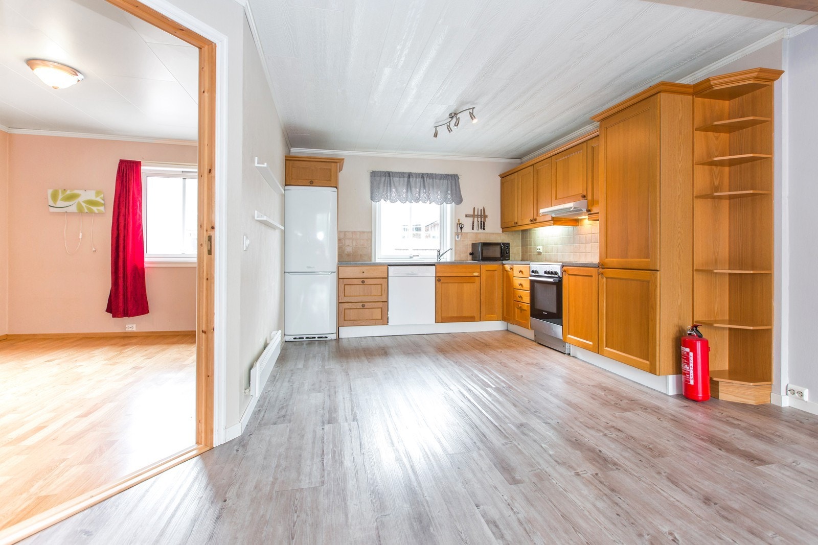 Kjøkkeninnredning i laminat utførelse med profilert heltre eik fronter.
Laminat benkeplater. Fliser på vegger over benkeplatene. Soverom 1 til venstre. Galleribilde