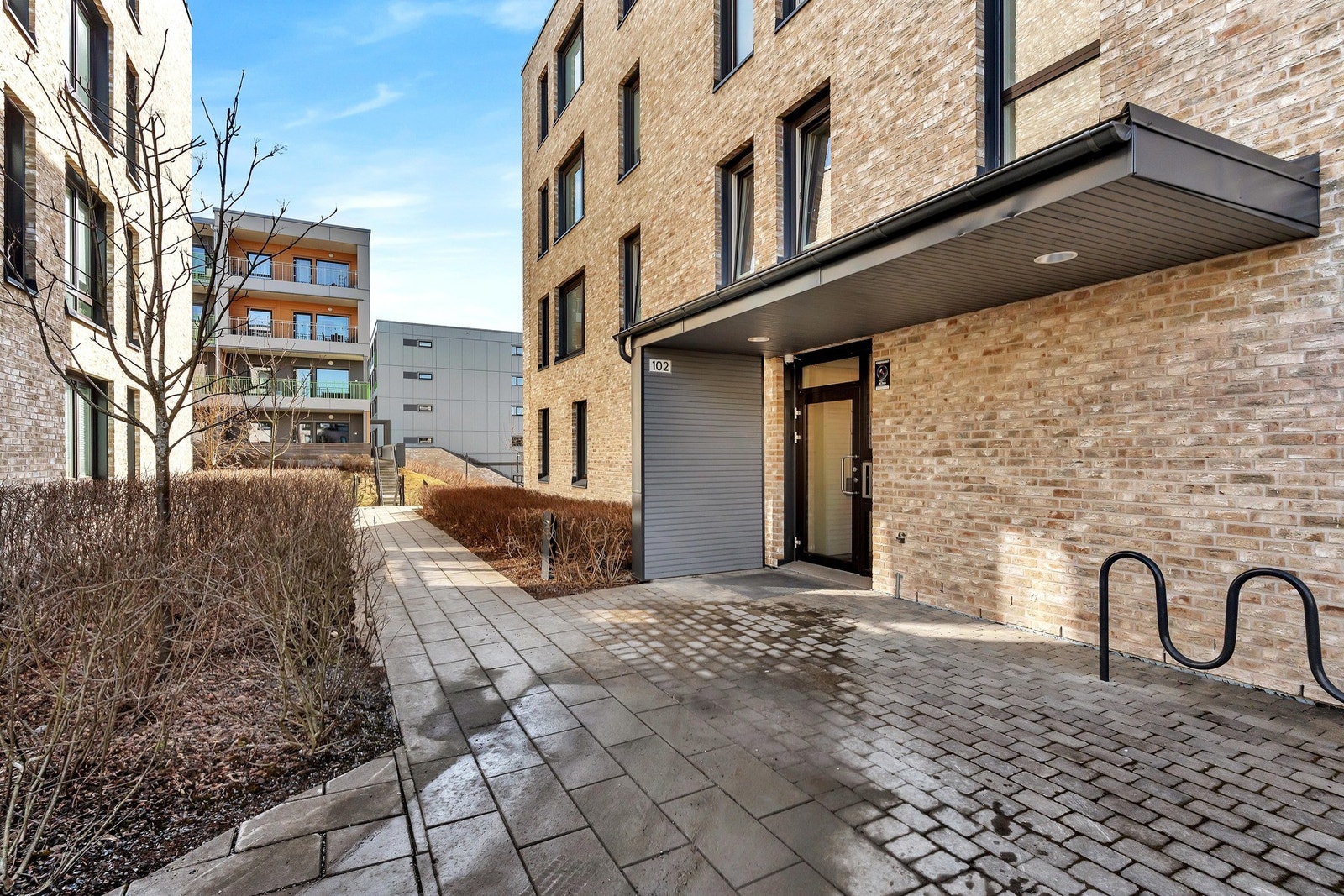 Inngangspartiet er opparbeidet med stein heller og sykkelstativ. Galleribilde