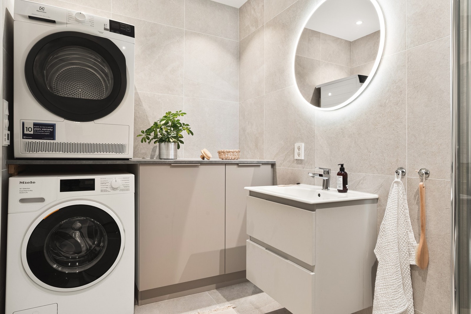 Badet er helfliset og måler ca. 4,5 kvm. Baderommet består av vegghengt toalett, dusj med glassvegger, opplegg for vaskemaskin og servant. Galleribilde