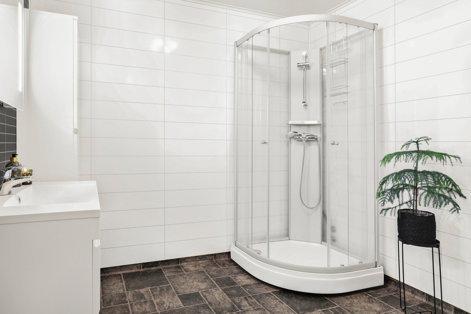 Det er gulvbelegg med gulvvarme på gulv og baderomsplater på vegg. Galleribilde