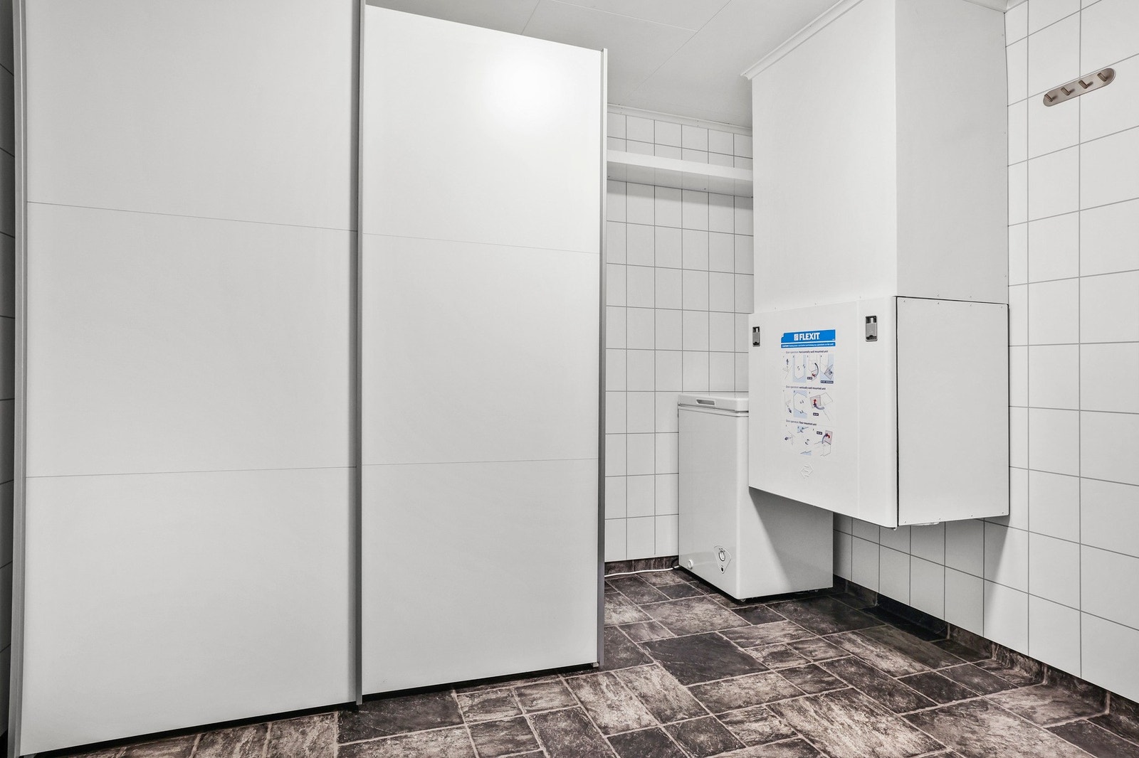 Vaskerommet har vegghengt utslagsvask med armatur og opplegg for vaskemaskin. Galleribilde