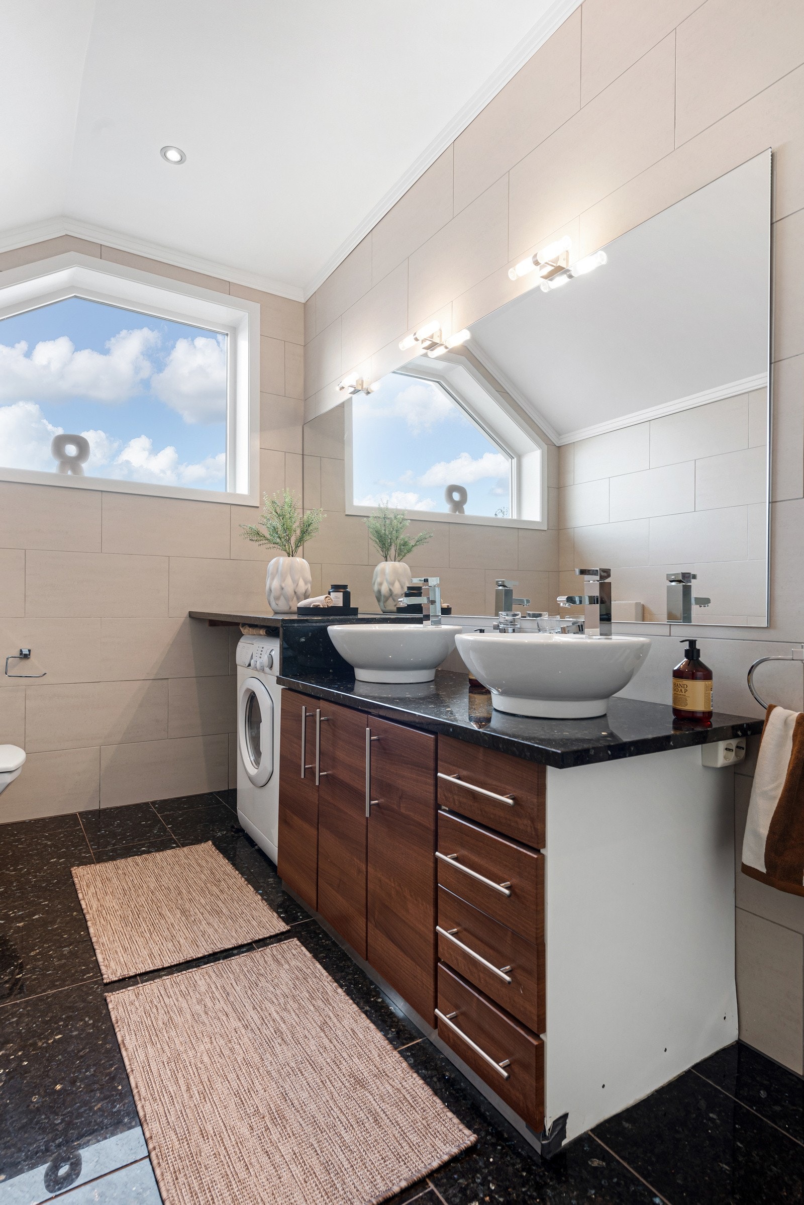 Badet er innredet med servantskap, dusjnisje, toalett og opplegg til vaskemaskin Galleribilde