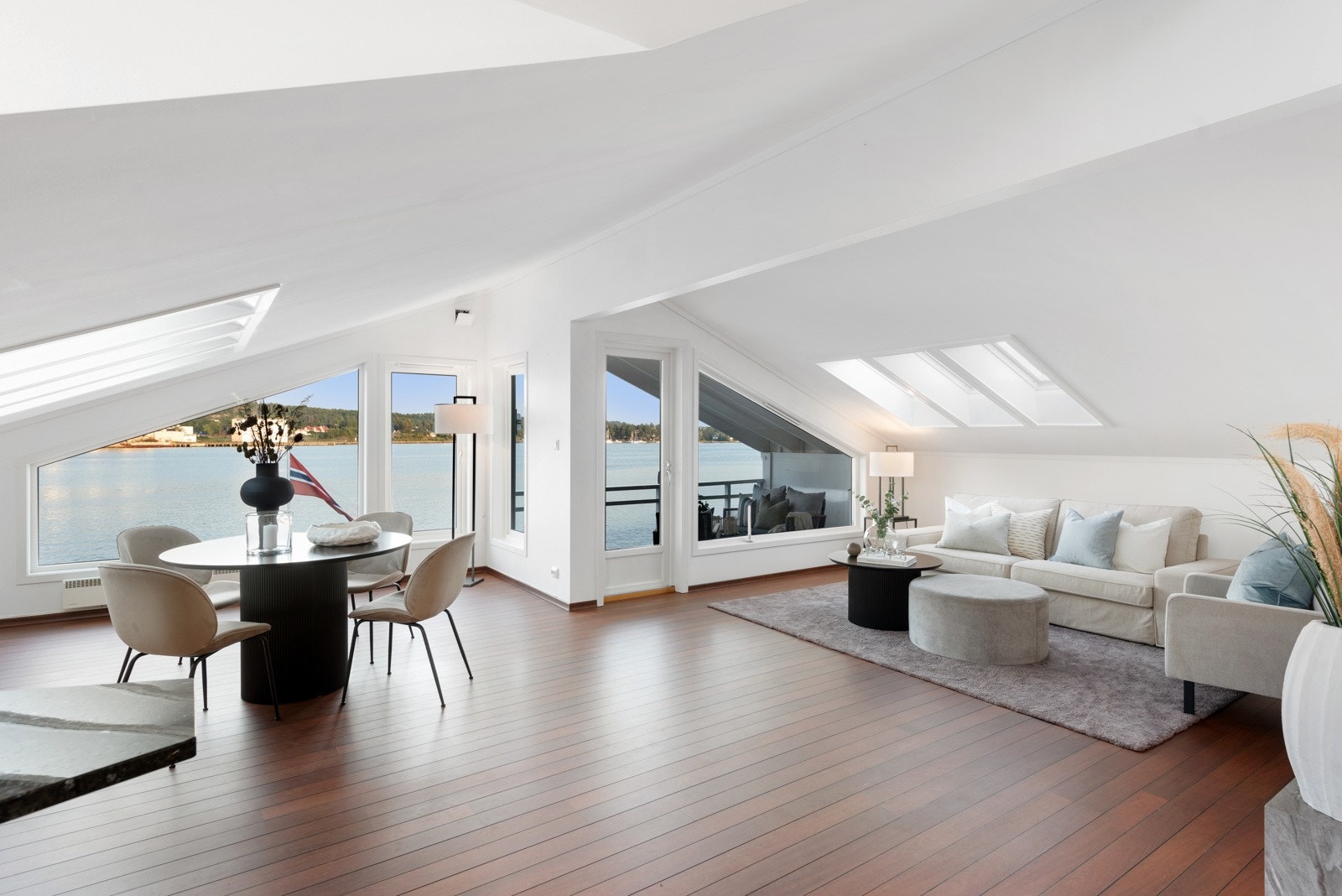 Lys, tiltalende stue med rikelig med lysinnsplipp fra store vindusflater Galleribilde