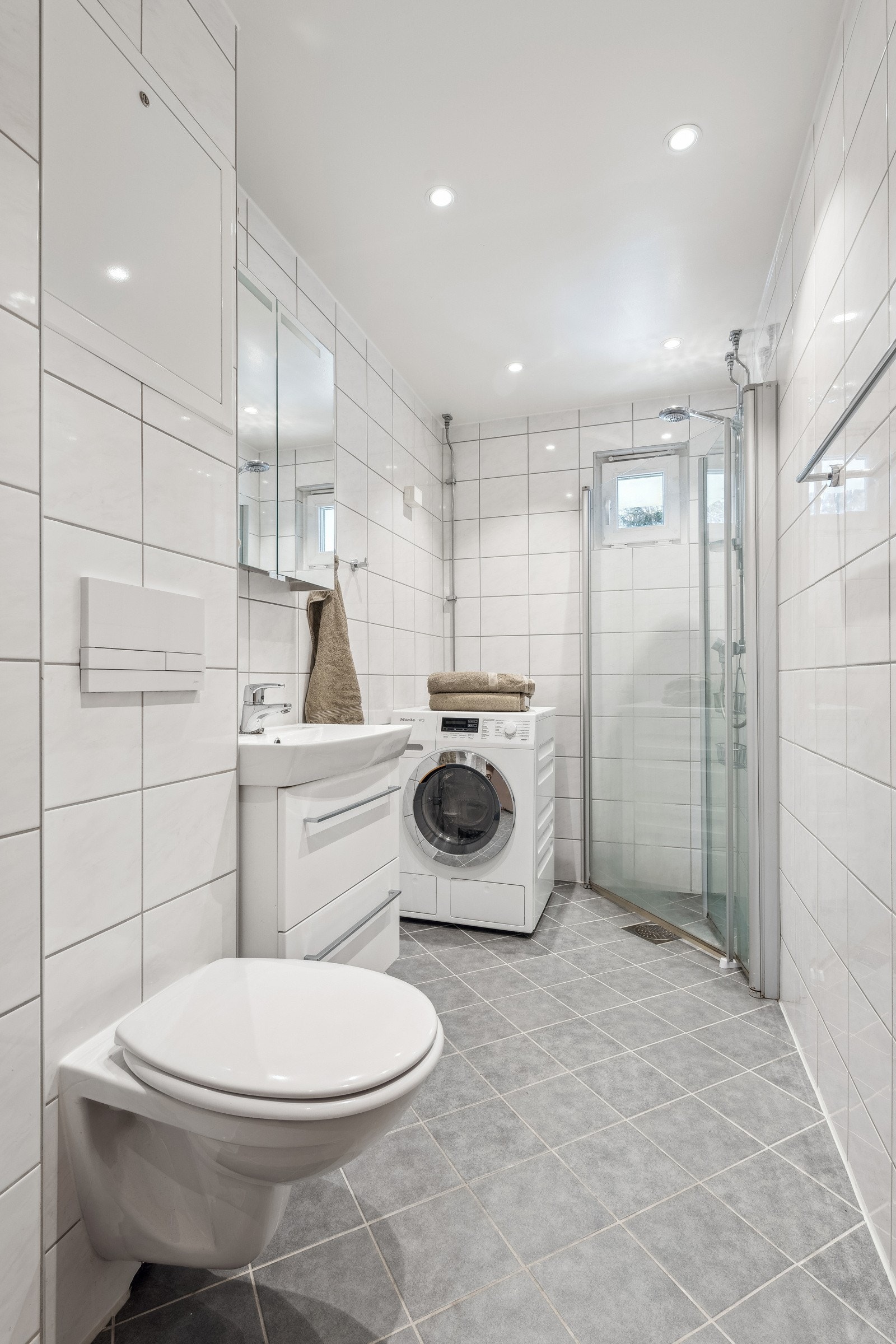 Baderom av god størrelse med opplegg for vaskemaskin Galleribilde