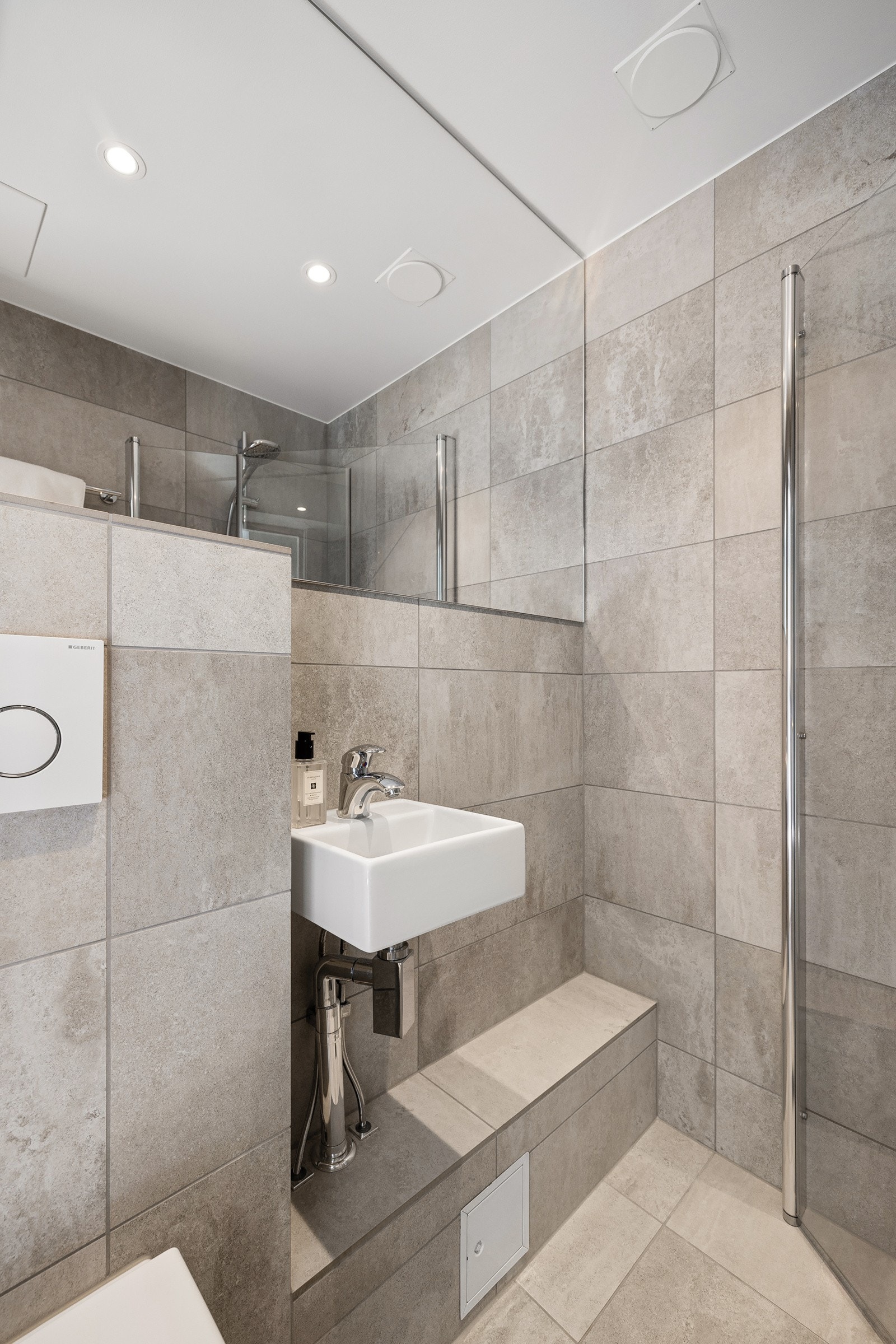 løsning med herdet glass gir en åpen og luftig følelse, mens vegghengt toalett med innebygget sisterne sikrer et rent og ryddig uttrykk. Galleribilde