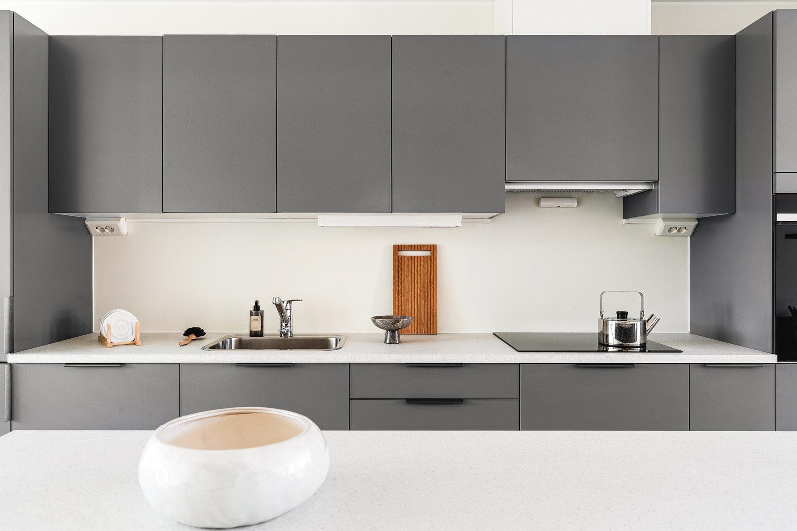 Innredningen har slette fronter og laminat benkeplate med nedfelt vask av stål. Galleribilde