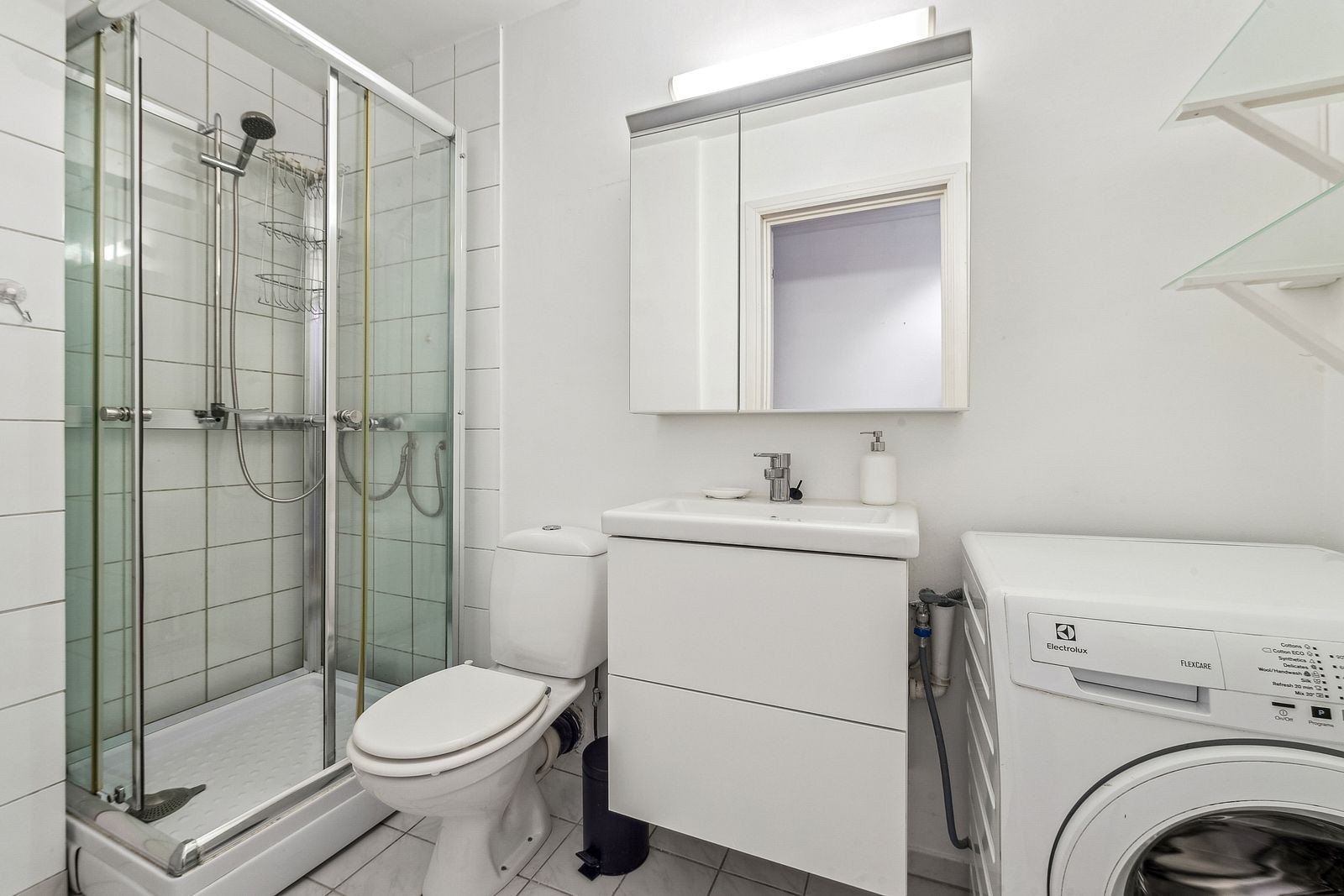 Baderom med dusjkabinett og vaskemaskin. Galleribilde
