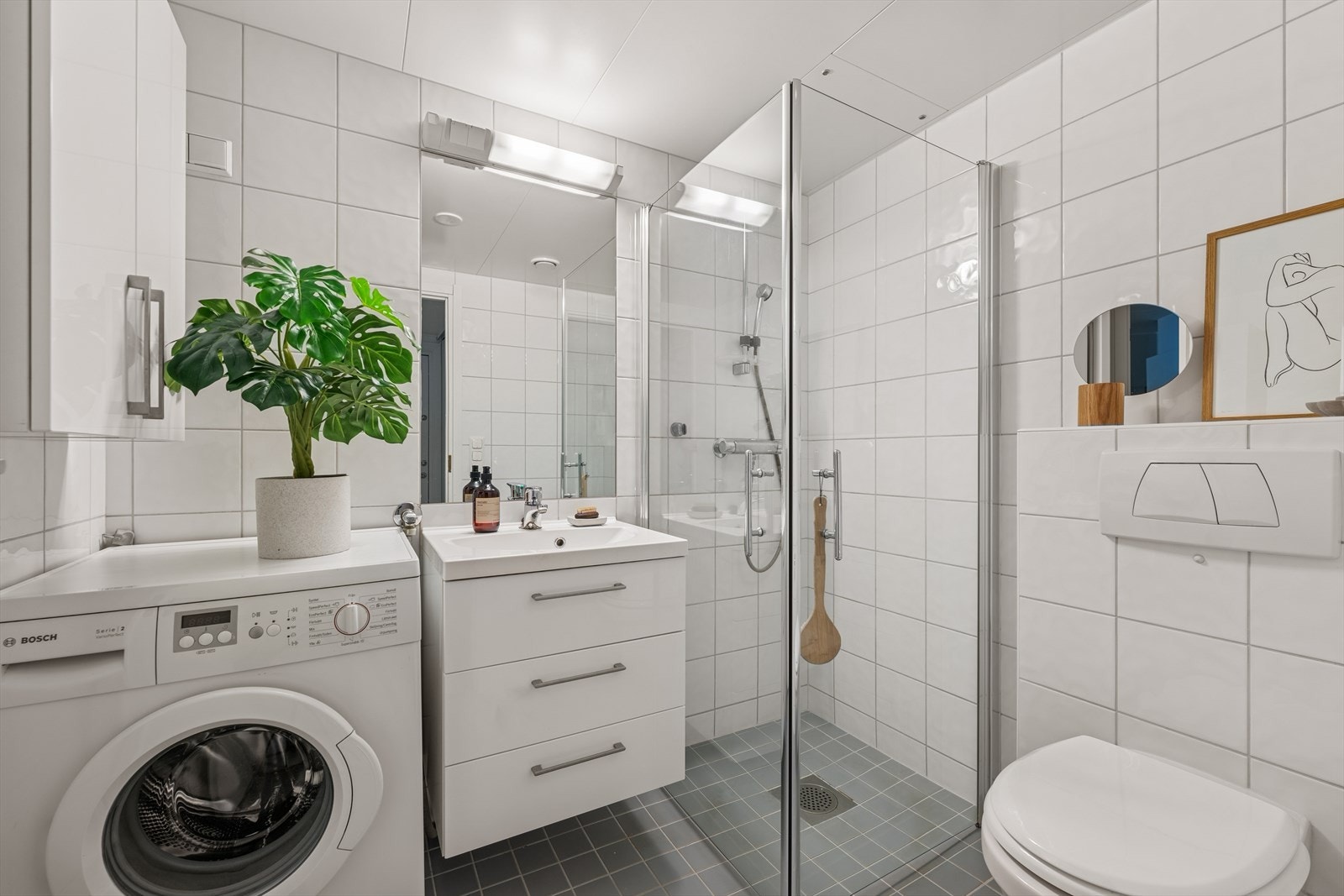 Boligen har et stilrent baderom med flislagt gulv og vegger, samt behagelige varmekabler i gulv. Galleribilde