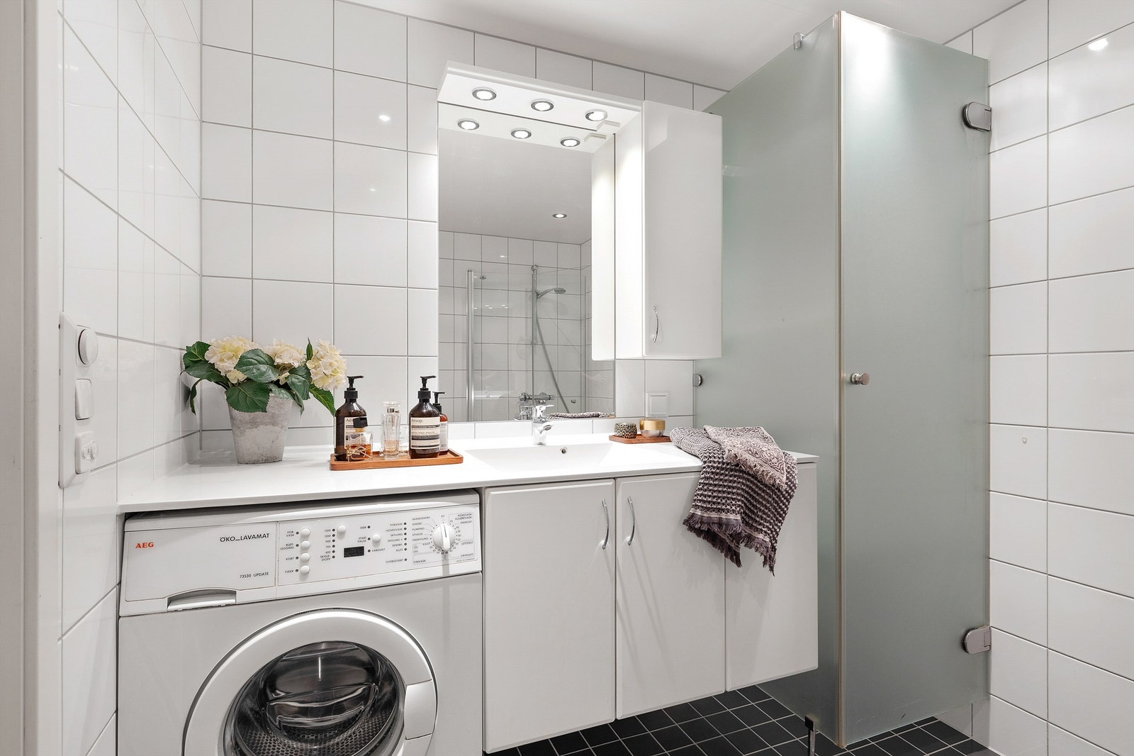 Innmurt speil, overskap og overlys med stikkontakt på vegg over servant. Skap for klestørking ved servantskap. Galleribilde