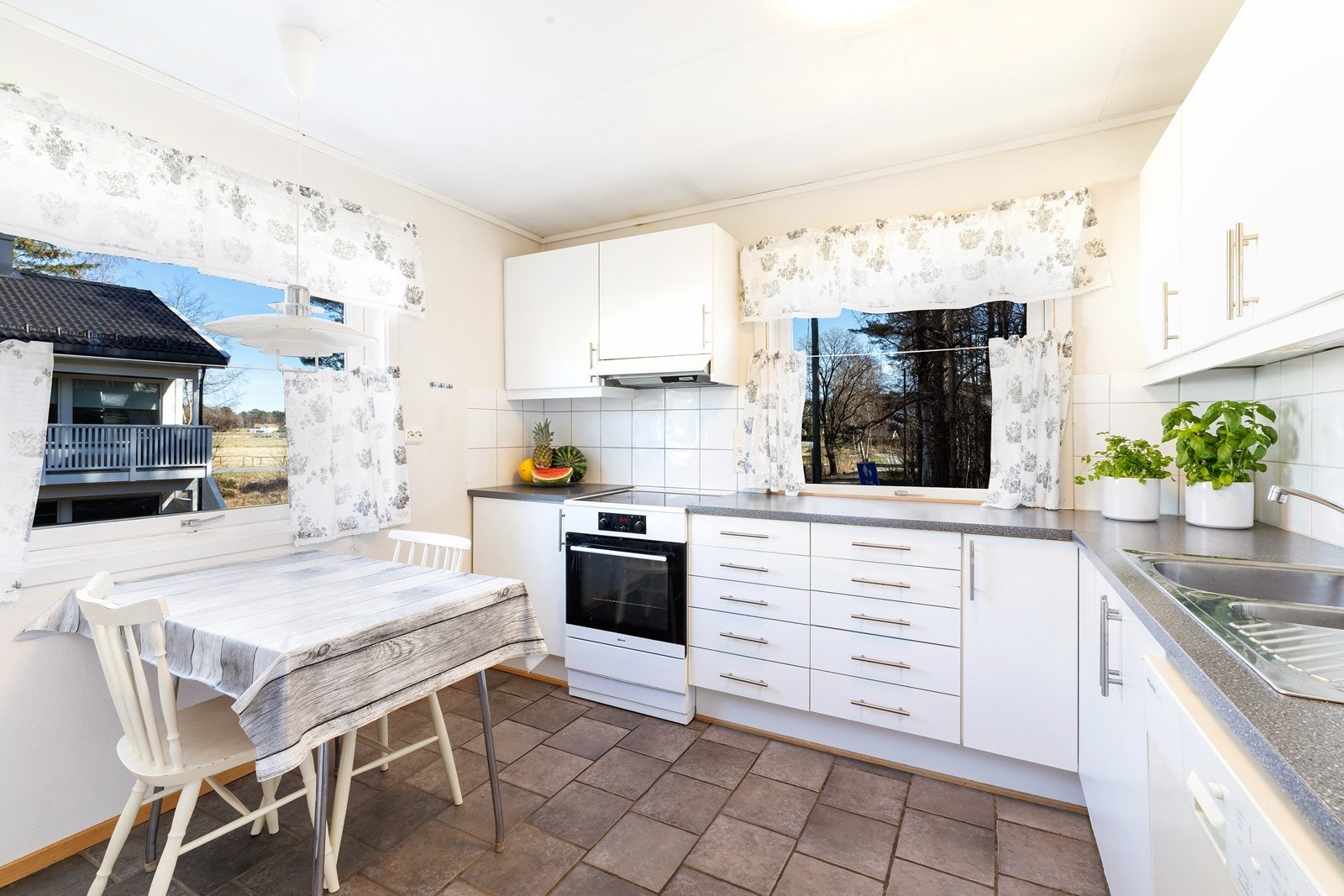 Kjøkken med plass til kjøkkenbord ved vinduet, her er god skap og benkplass Galleribilde