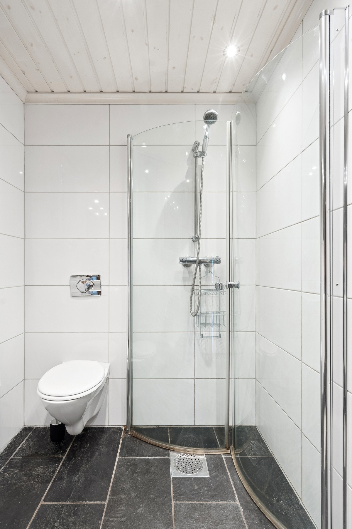 Badet er innredet med nedfelt servant, veggmontert toalett og dusjvegger. Galleribilde