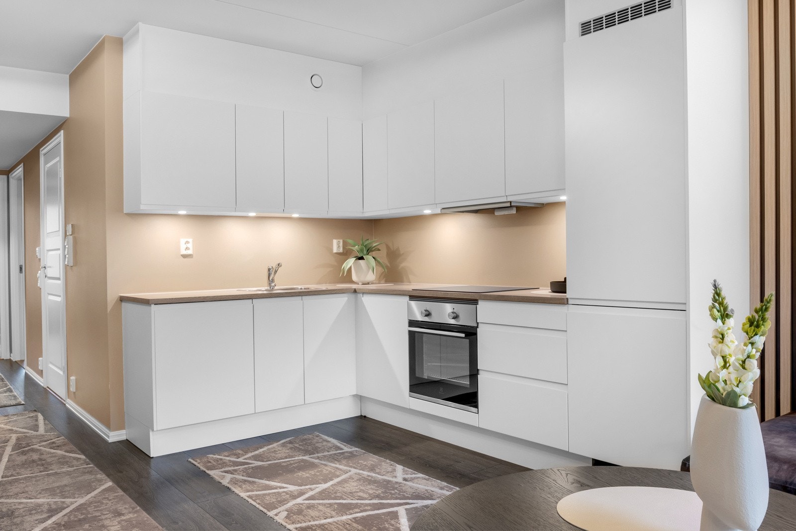 Belysning under høyskapene og to stikkontakter for kjøkkenutstyr. Galleribilde