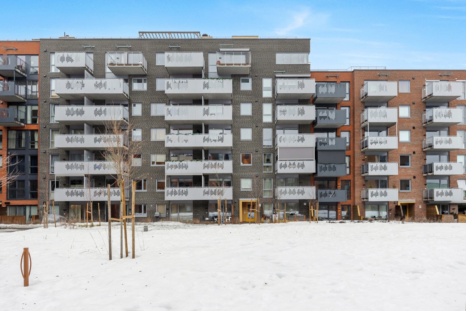 Flat tomt, pent opparbeidet med plen, prydbusker og lekeplass. Asfaltert adkomst til blokka. Galleribilde