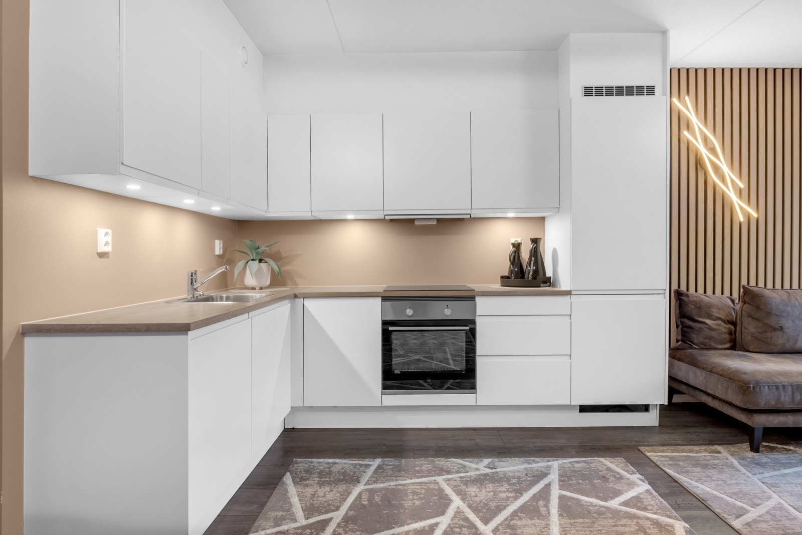 Stilig kjøkkeninnredning med hvite benk- og skapfronter. Galleribilde