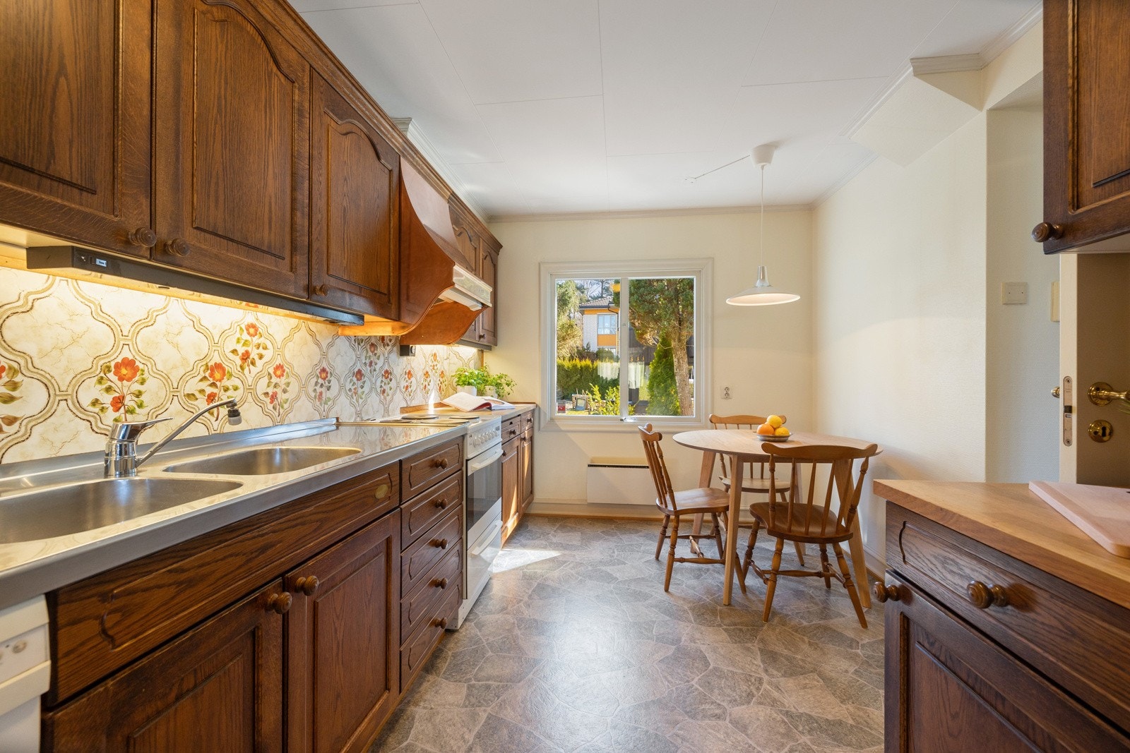 Kjøkkenet er innredet med benkeplater i heltre og stål, samt en enkel, plateslått backsplash. Galleribilde
