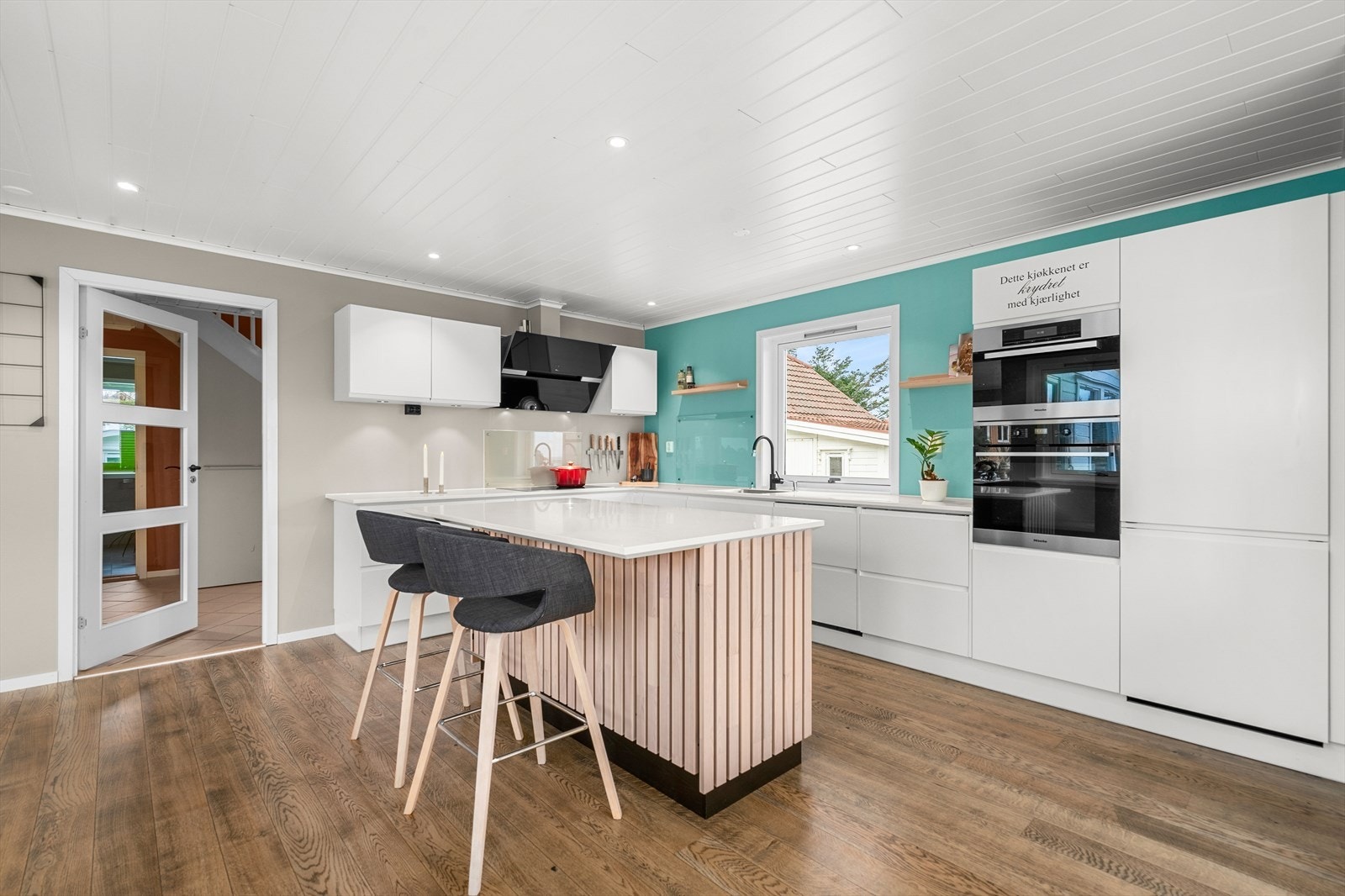 Påkostet og pen kjøkkeninnredning med integrerte hvitevarer; kjøleskap, fryseskuff, oppvaskmaskin, platetopp, stekeovn, dampovn og vannstoppsystem. Galleribilde