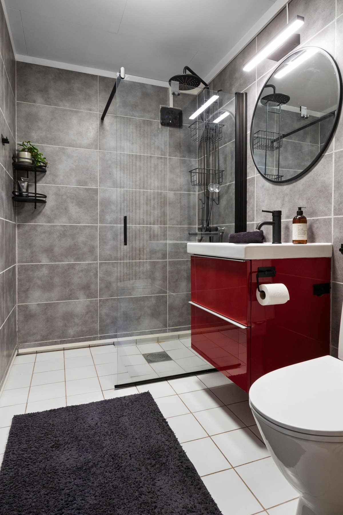 Badet ble pusset opp i 2022, og har grå våtromsplater i flisimitasjon på veggene og hvite fliser på gulv med gulvvarme. Galleribilde