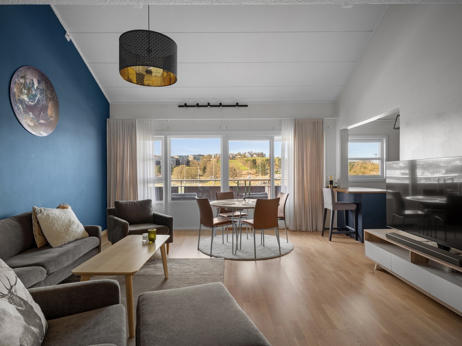 Lys og moderne stue med store vinduer og flott utsikt, perfekt for avslapning og sosiale sammenkomster. Galleribilde