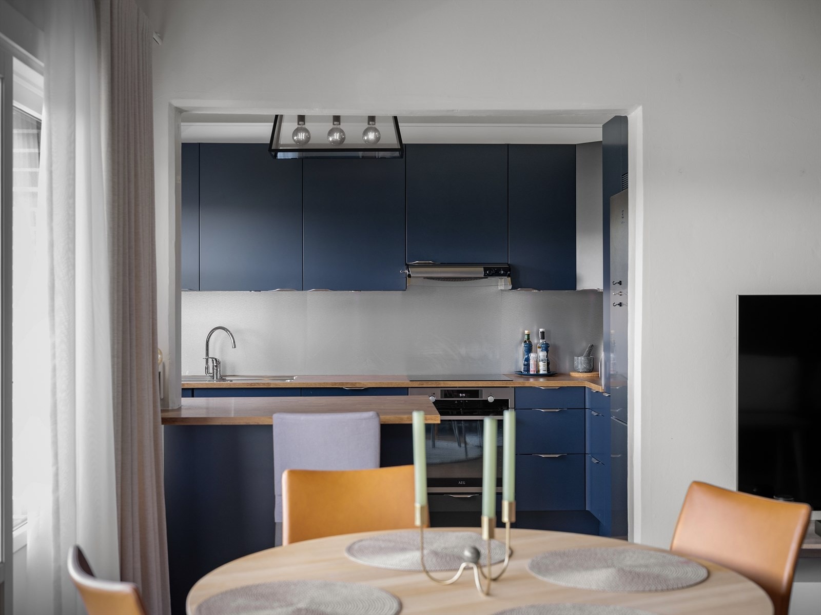 Moderne kjøkken i åpen løsning med stilrene detaljer, perfekt for sosialt samvær og matlaging. Trivelig spisestue med naturlig lys. Galleribilde