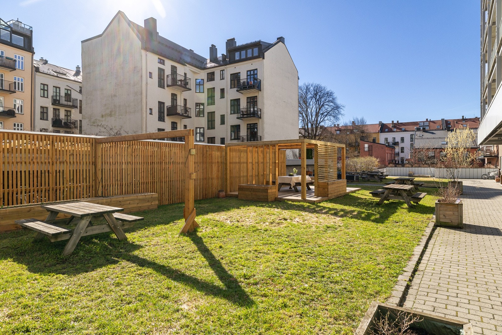 Idyllisk og pent opparbeidet bakgård med gressplen, sittegrupper m.m. Galleribilde