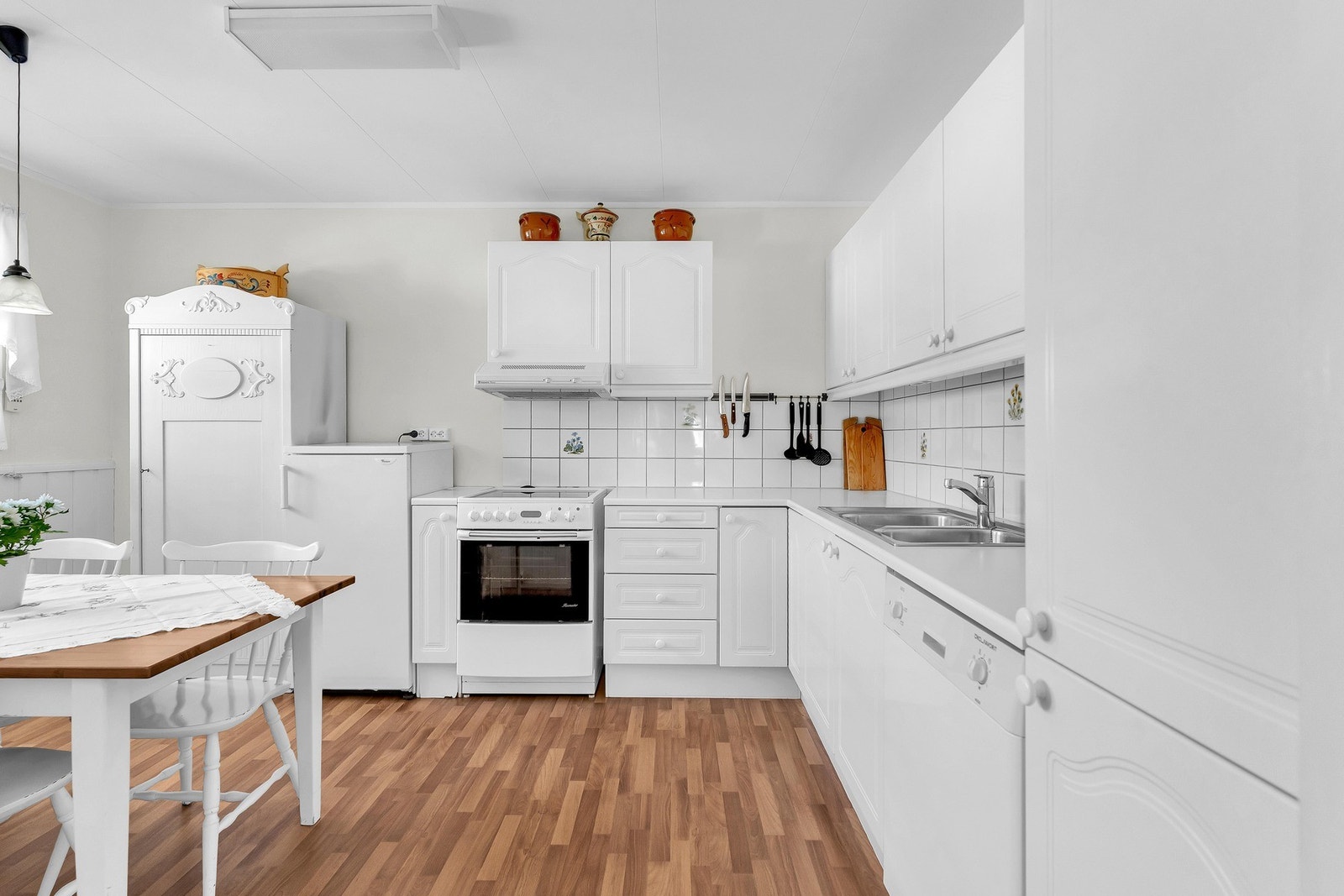 Kjøkkenet er utstyrt med nedfelt oppvaskkum av rustfritt stål og ett-greps armatur, benkeskapsbelysning og stikkontakter under overskap. Galleribilde