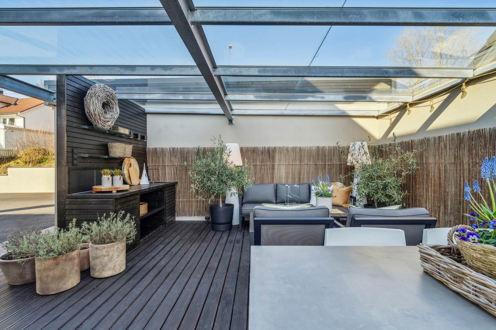 Terrassen mot nord er delvis innebygd med glasstak og glassdør, og her nytes livet utendørs selv når det regner. Galleribilde