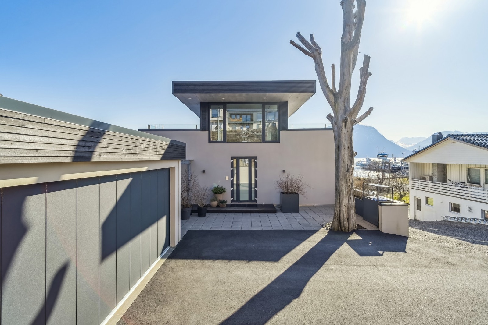 Et stilig inngangsparti ønsker velkommen, med glassdør, belysning og god plass til benker eller kafésett. Galleribilde