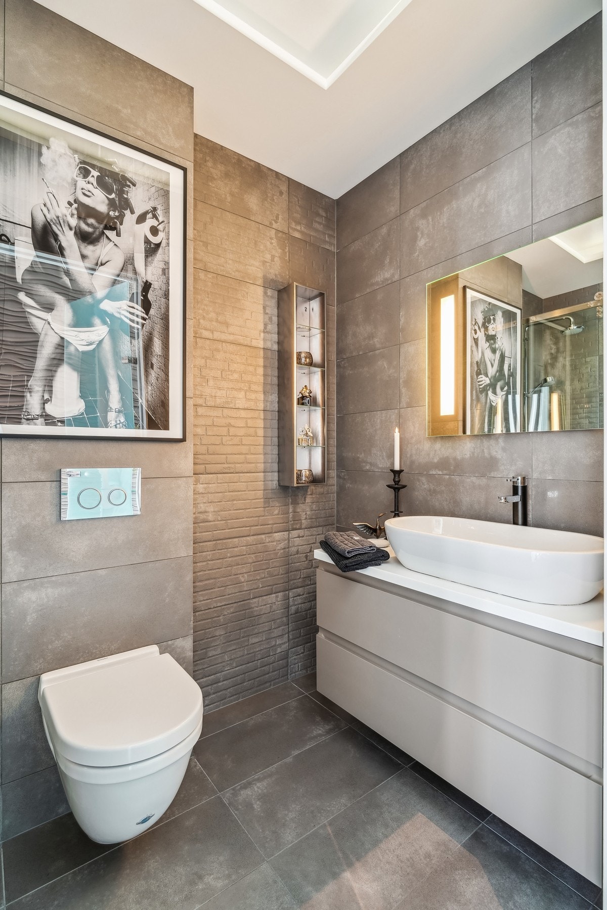 Det andre badet har gulvvarme, moderne innredning og et stilrent uttrykk med store fliser. Galleribilde