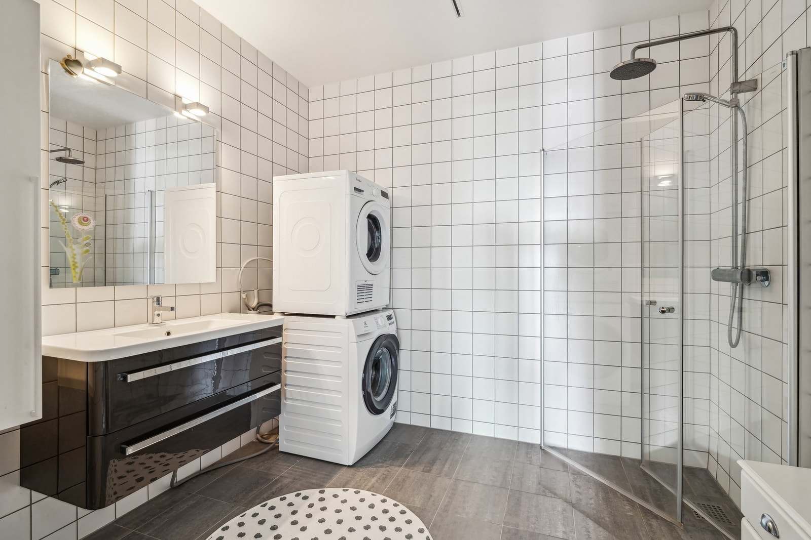 Badet i leiligheten er helfliset, utstyrt med gulvvarme, regnfallsdusj og opplegg for vaskemaskin. Galleribilde