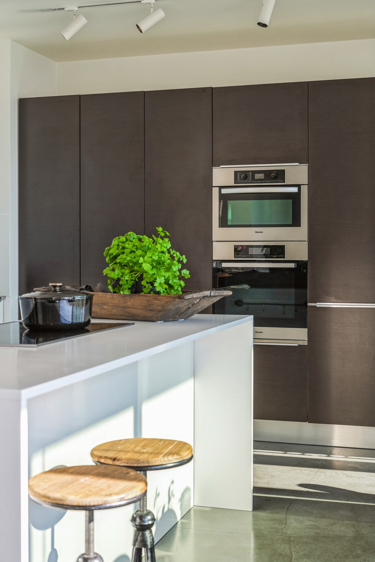 Ovnene er praktisk plassert i et høyskap, og ved platetoppen lages maten - Galleribilde