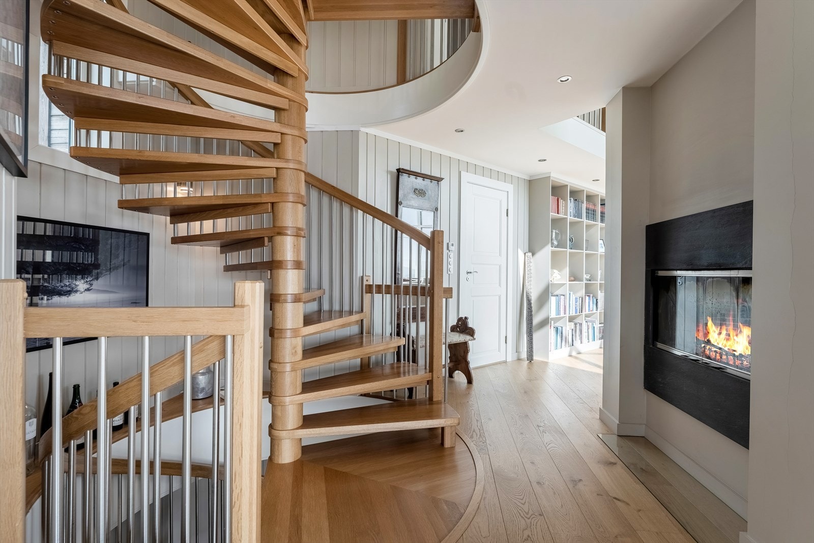 Trapperom ligger bak søylen med peis på begge sider. Galleribilde