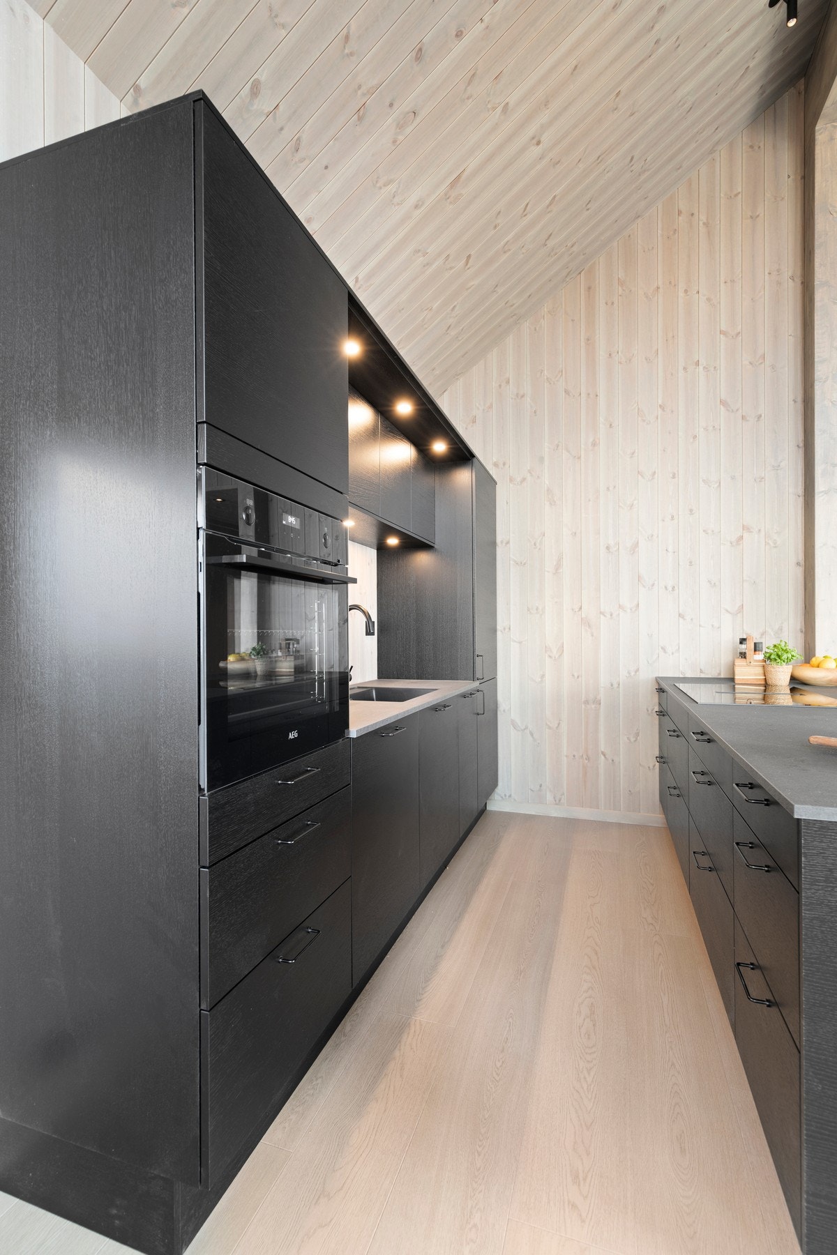 Innredningen inneholder overskap, laminat benkeplate og integrerte hvitevarer fra Siemens; stekeovn, oppvaskmaskin, kjøleskap med frysedel og platetopp med ventilator. Galleribilde