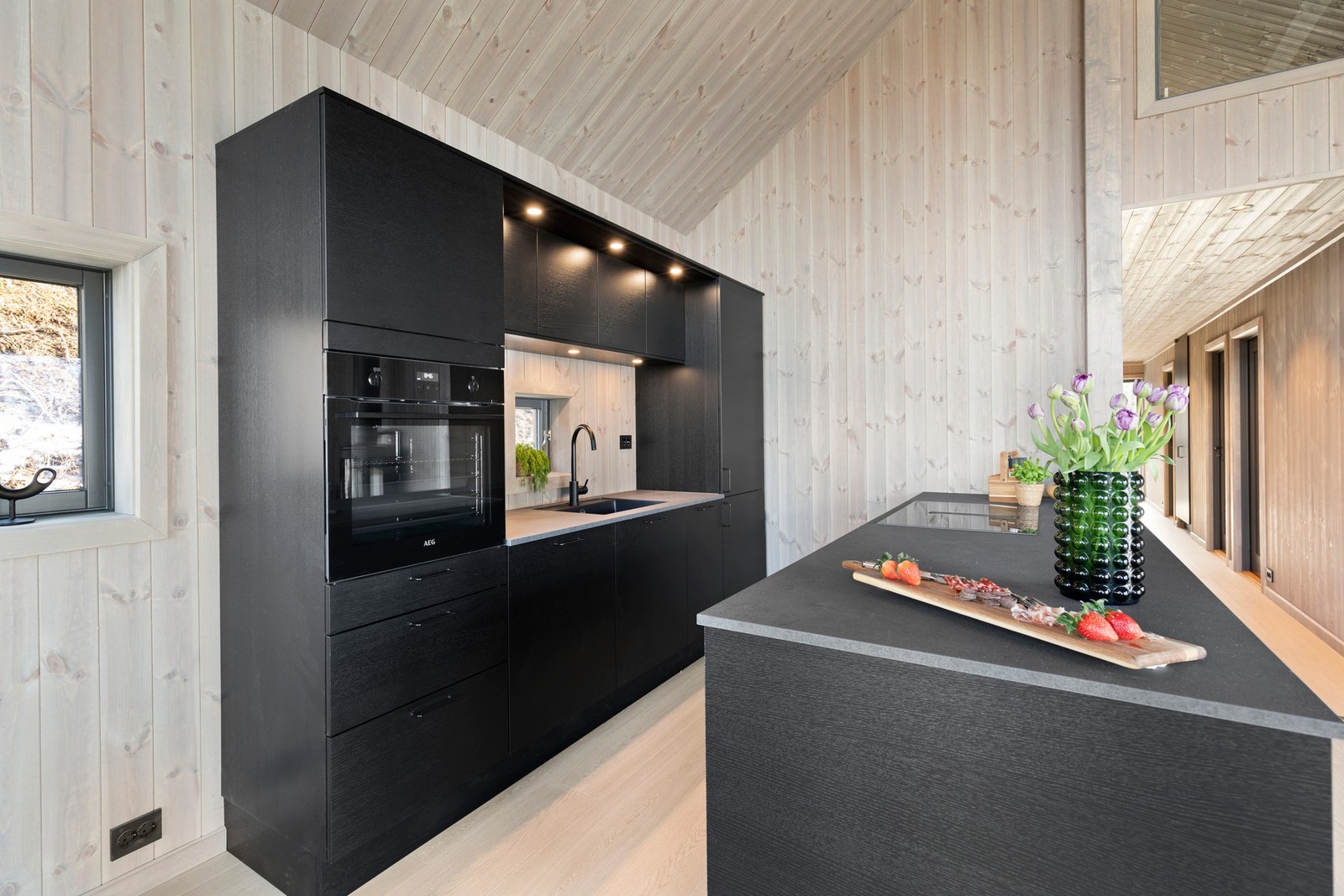 Pen kjøkkeninnredning fra HTH i sorte, slette eikefronter. Galleribilde