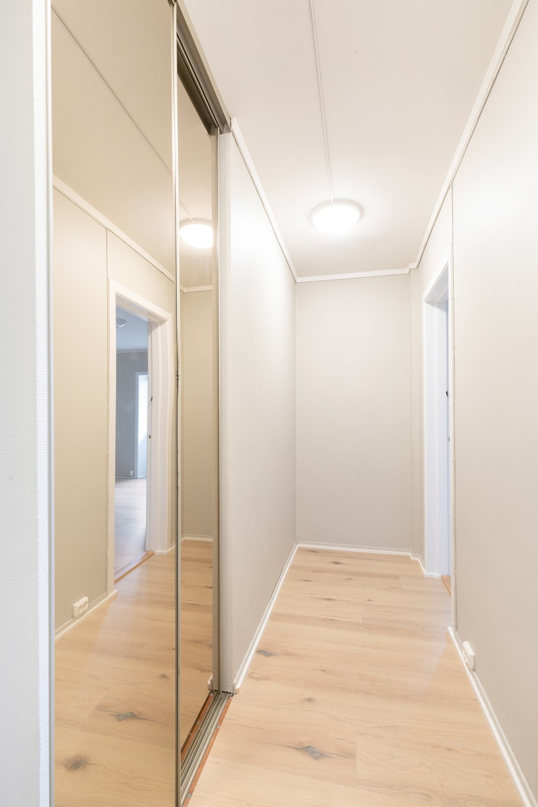 Gangen har skyvedørsgarderobe med speil Galleribilde