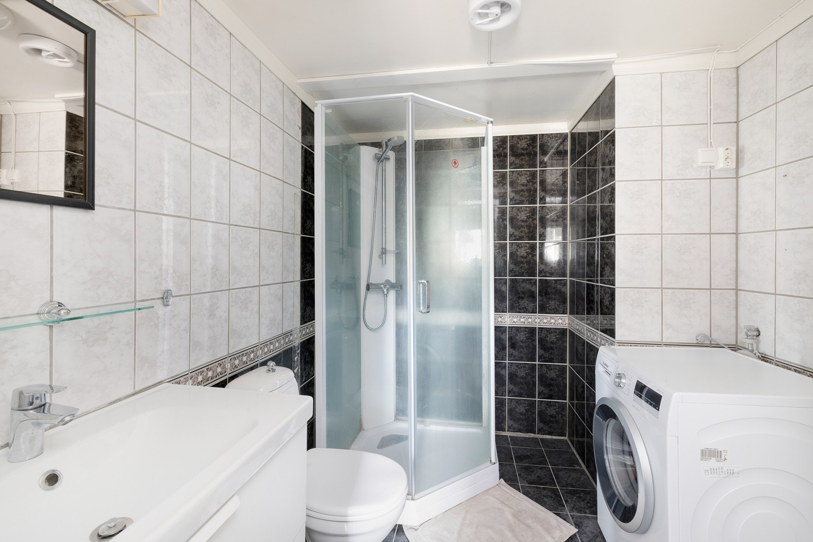 Flislagt bad med servant med skap. Dusjkabinett og WC. Her er også opplegg for vaskemaskin. Galleribilde