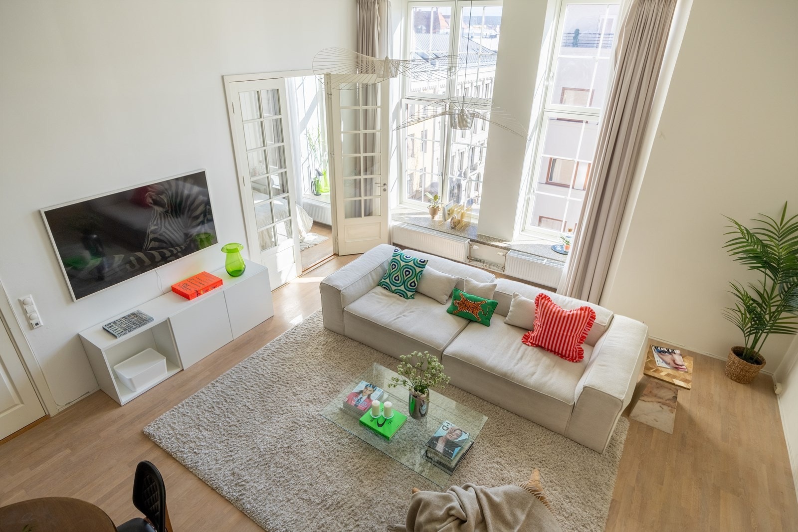 Stuen har en åpen og lys løsning som smelter sammen med kjøkkenet, noe som skaper en luftig og sosial atmosfære Galleribilde