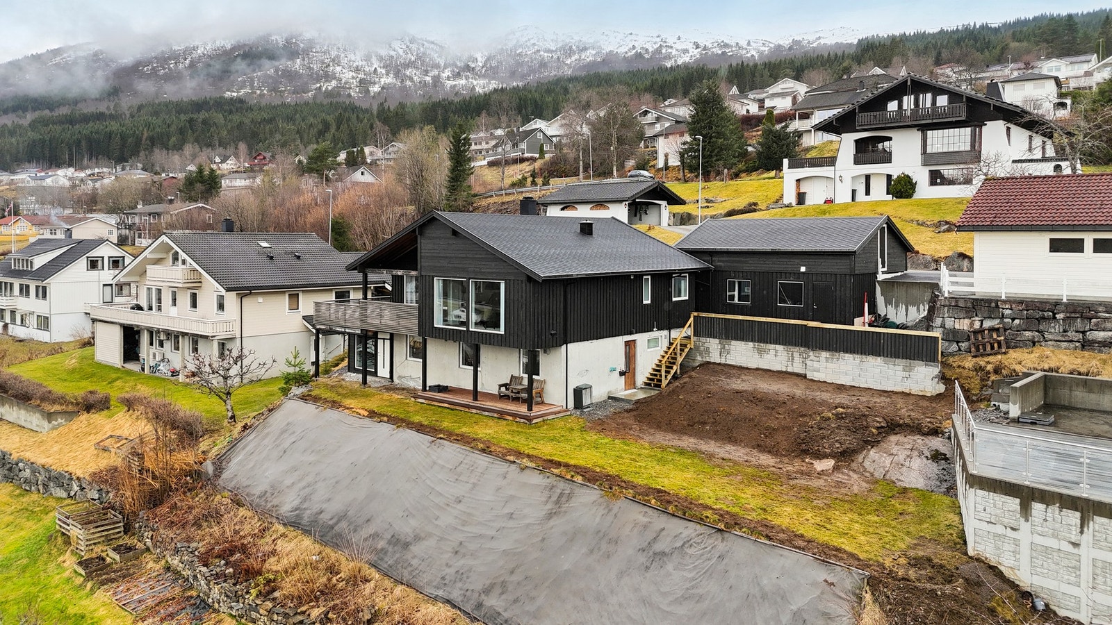 I nedkant av eiendommen er det etablert terrasse, satt opp ny forstøtningsmur i 2025, og klargjort for hageareal Galleribilde