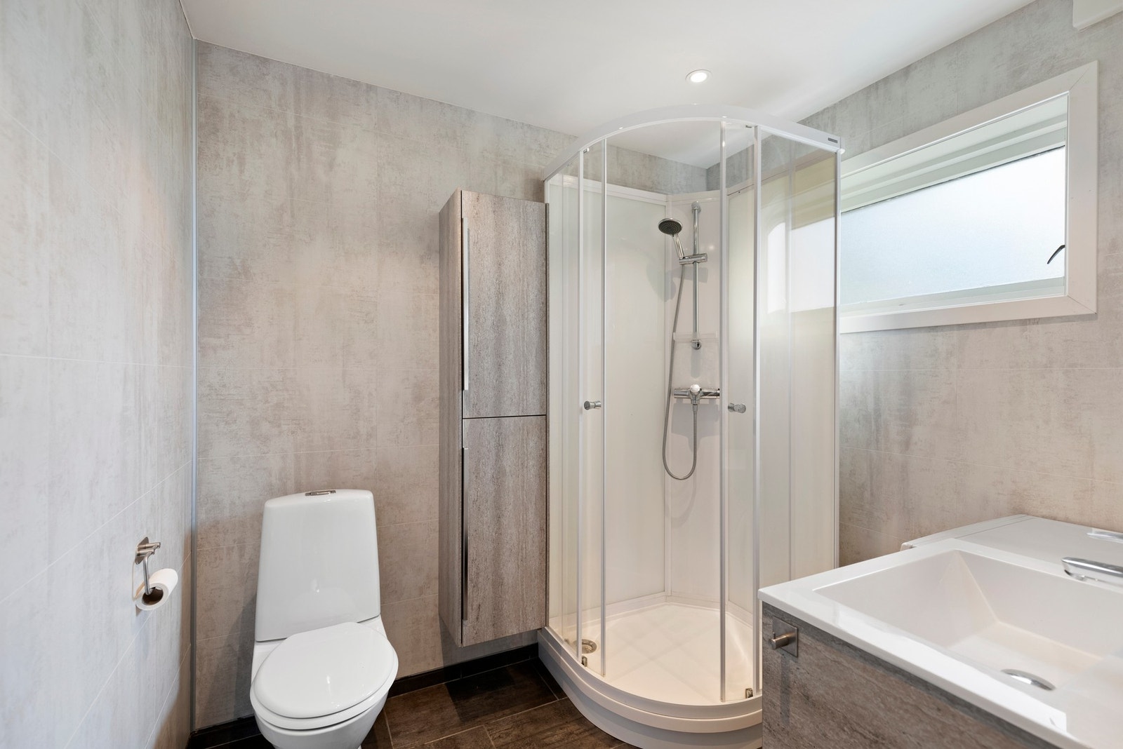 Badet/vaskerom i underetasjen ble renovert i 2019, og er utstyrt med ny gulvvarme, downlights, baderomsinnredning, avtrekksvifte, toalett, dusjkabinett og opplegg for vaskemaskin Galleribilde